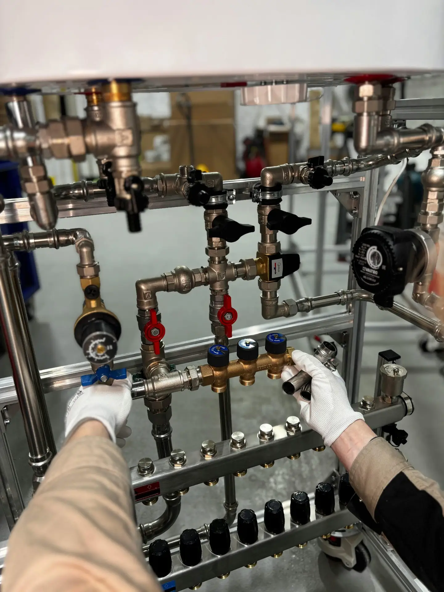 Engineer adjusting metal pipeline valves in an industrial setting with precision.