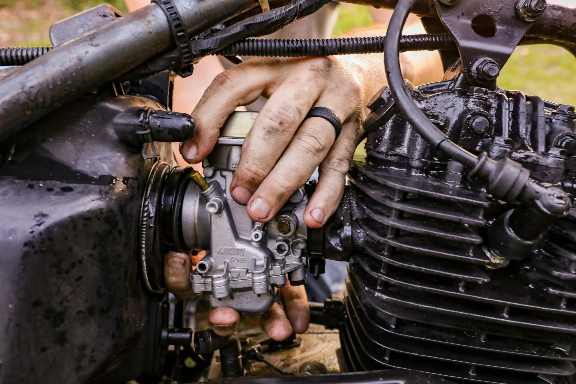 Close-up of hands fixing a motorcycle engine with tools in Orlando.